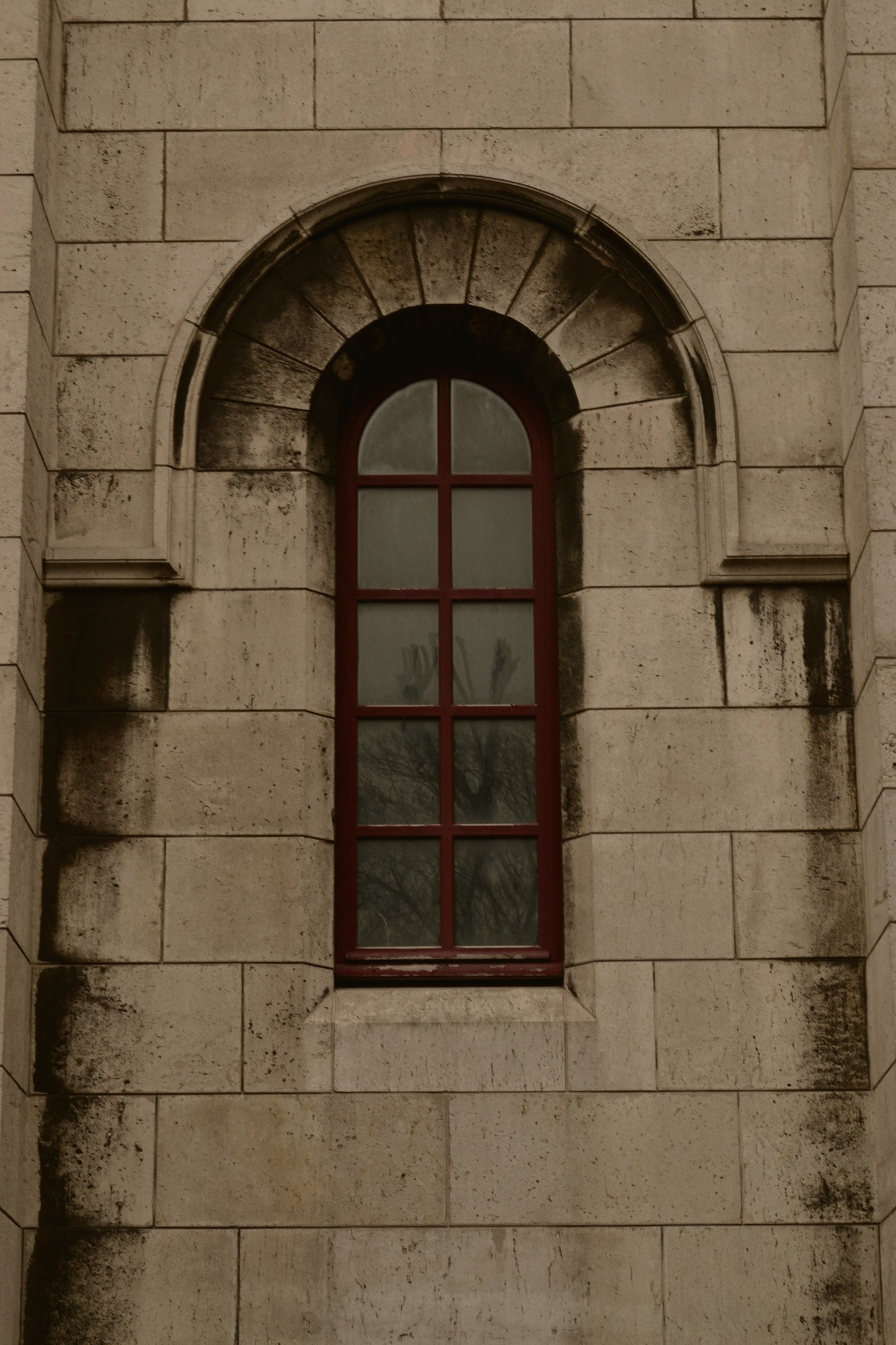 Fenêtre en arche d'un immeuble parisien, écho du guichet Guichet